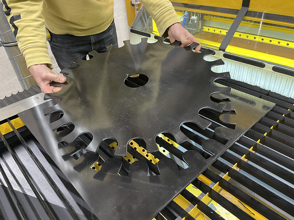 Laser operator unloads hdpe part from machine